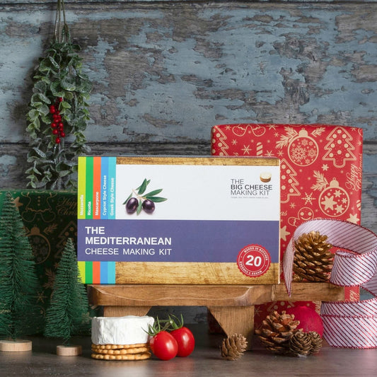 The Mediterranean Cheese Making Kit in front of a wrapped Christmas present