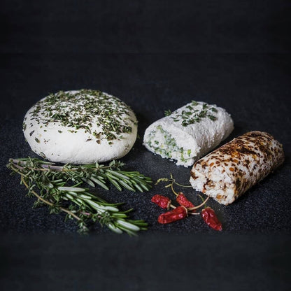 Three homemade Scottish crowdies: one topped with rosemary, one rolled with chives, one with chilli flakes