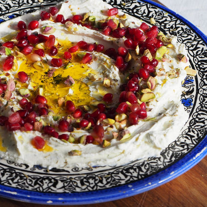 Homemade labneh with pomegranate seeds, pistachios and olive oil