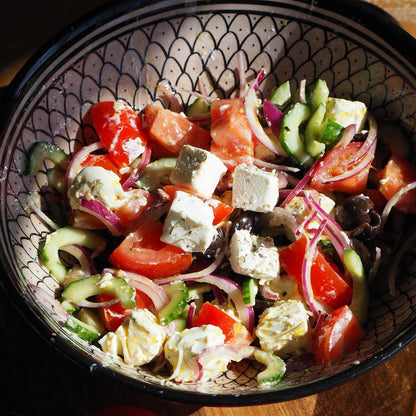 Greek salad with cubes of homemade Greek style cheese, tomato, cucumber, red onion and olives