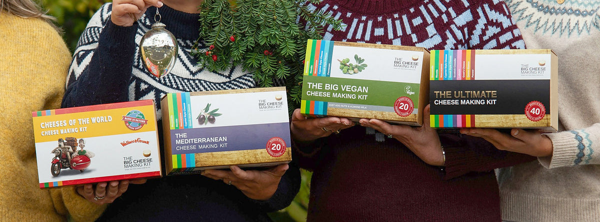 Four Big Cheese Making Kits held up in Christmas jumpers