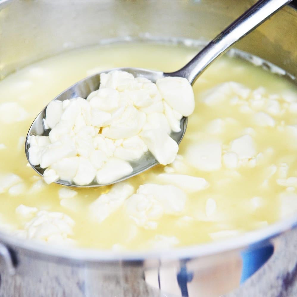 Wallace & Gromit's Cheeses of The World Cheese Making Kit by big cheese making kit. Fresh cheese curds in a pot with a spoon.