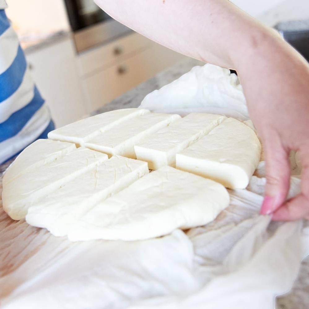 Big Cheese Making Kit Wallace & Gromit Squeaky Moon Cheese Making Kit, fresh white cheese cut into wedges on cheesecloth.